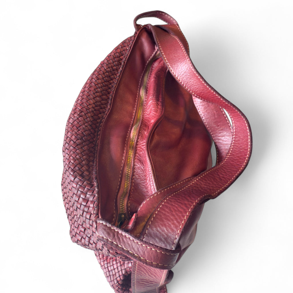Burgundy Italian woven leather handbag on a white background showing secure main zip closure. 
Made in Italy 
Converts to a backpack 
Sussex Kent Surrey Independent handbag retailer 