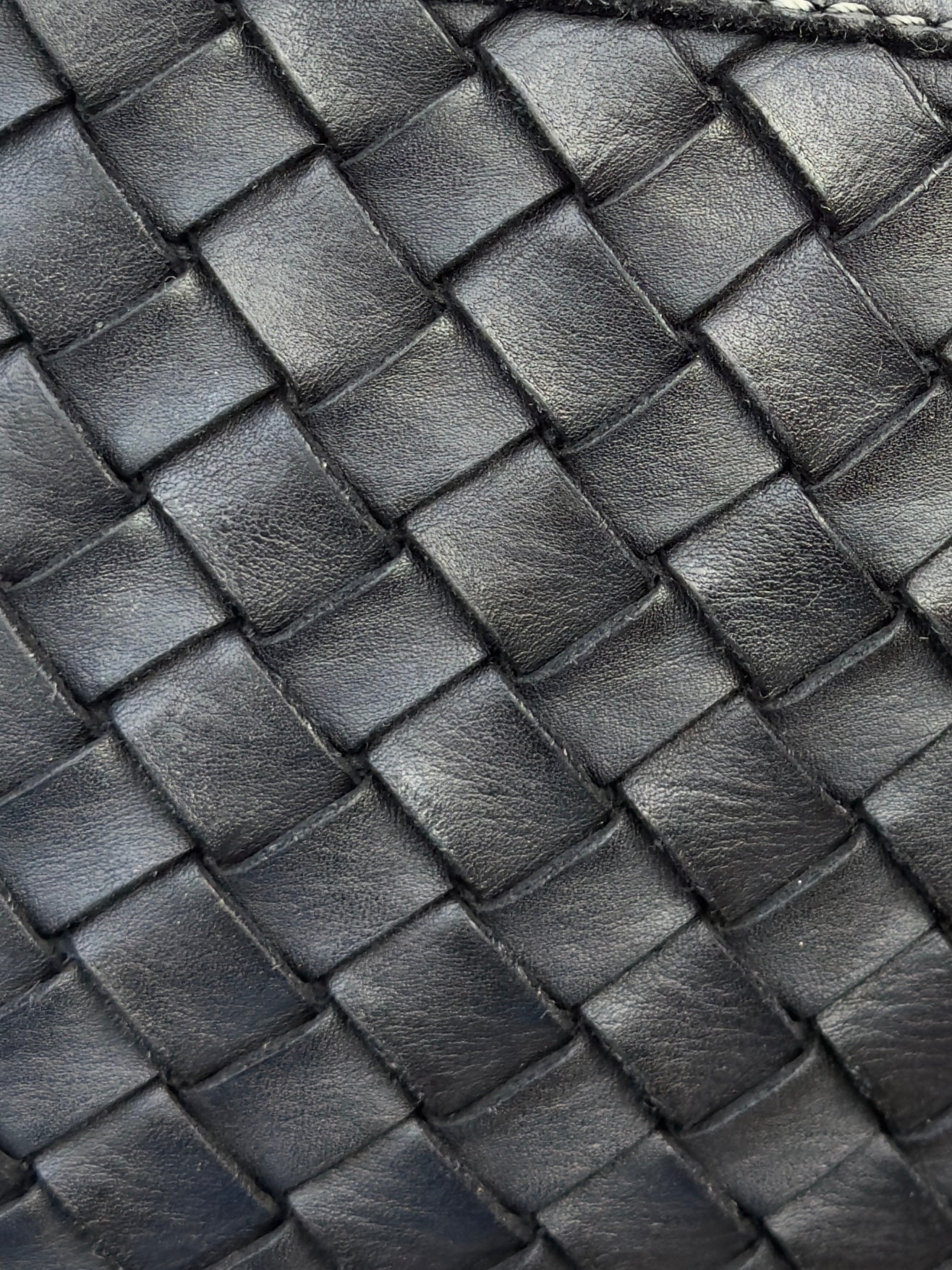 Close-up of a woven black leather texture bag