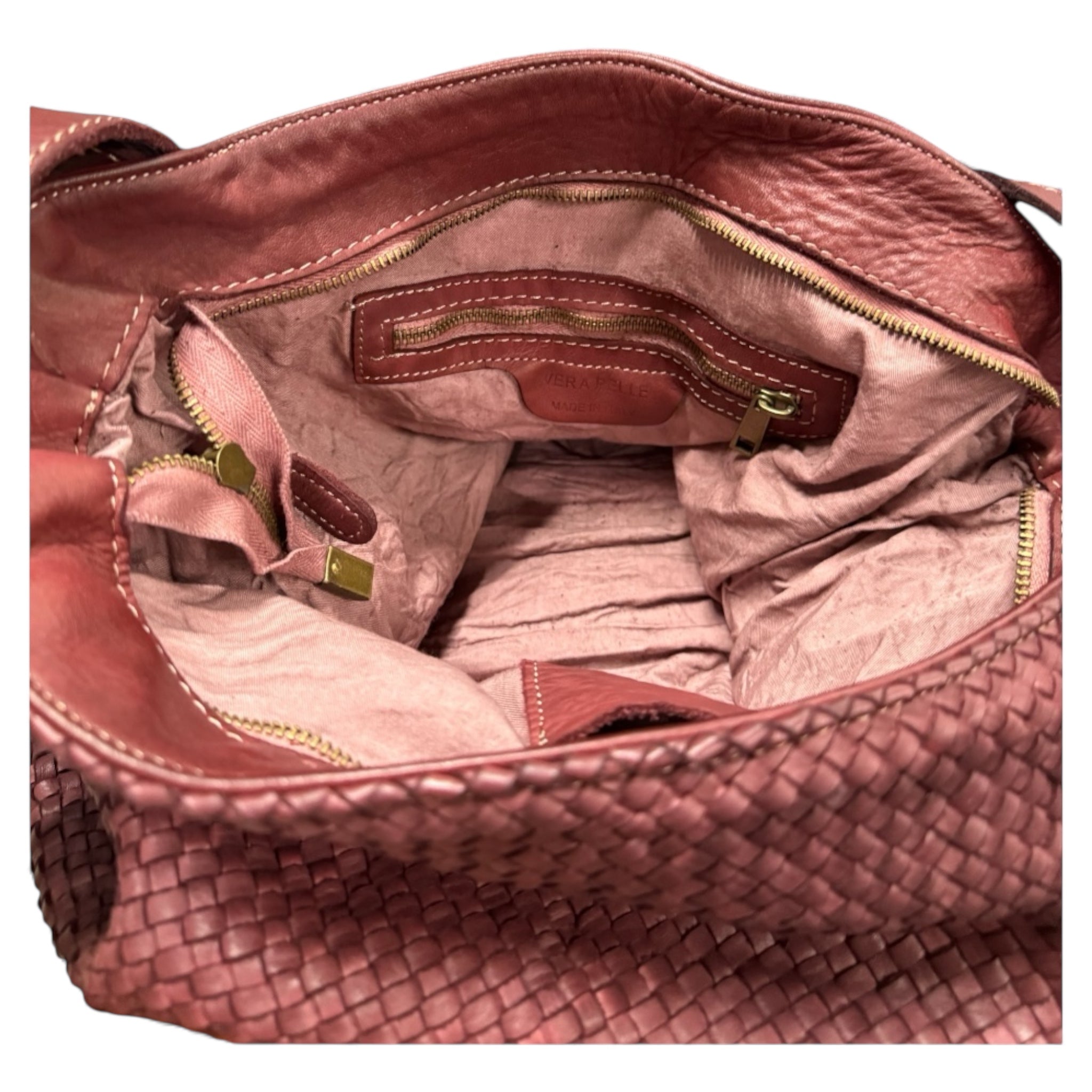 Showing the inside of a handwoven leather handbag inside zipped pocket  