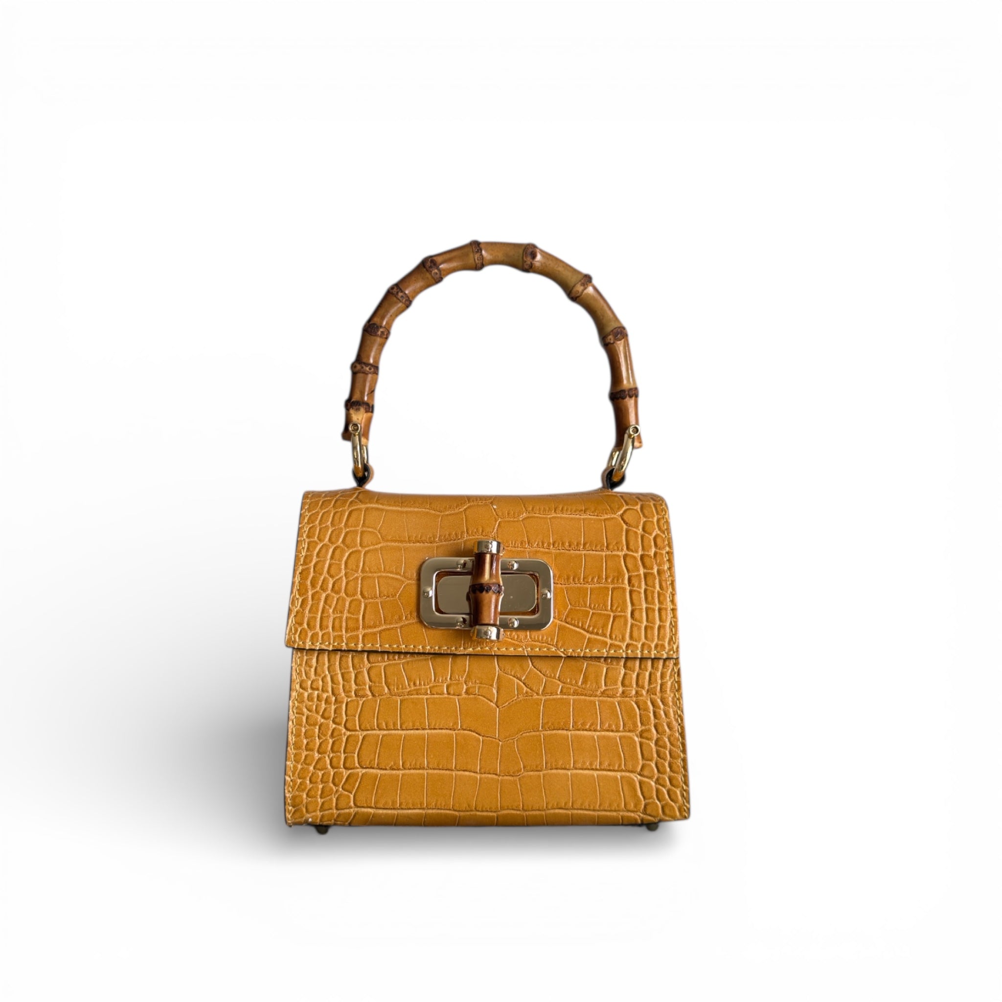 Yellow leather handbag with a bamboo handle on a white background