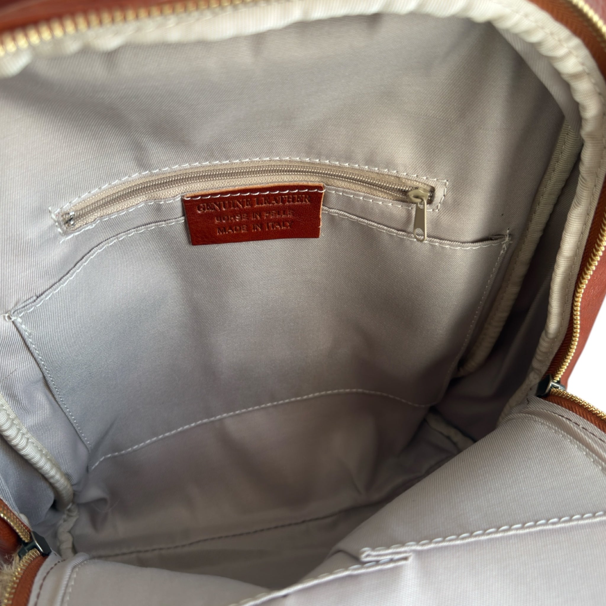 Close-up of a tan Italian leather back pack bag with  Cossu brand.