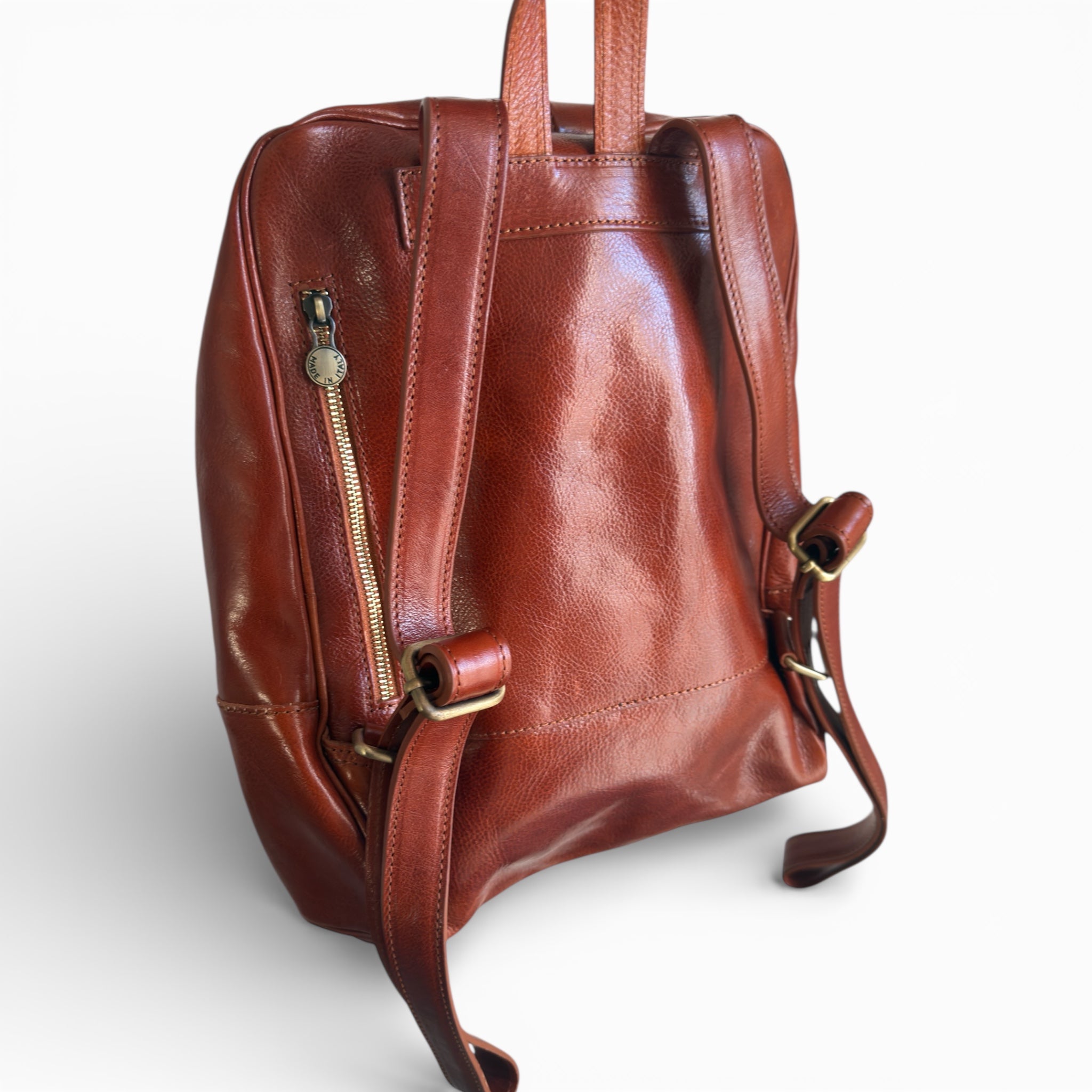 Tan leather backpack on a white background