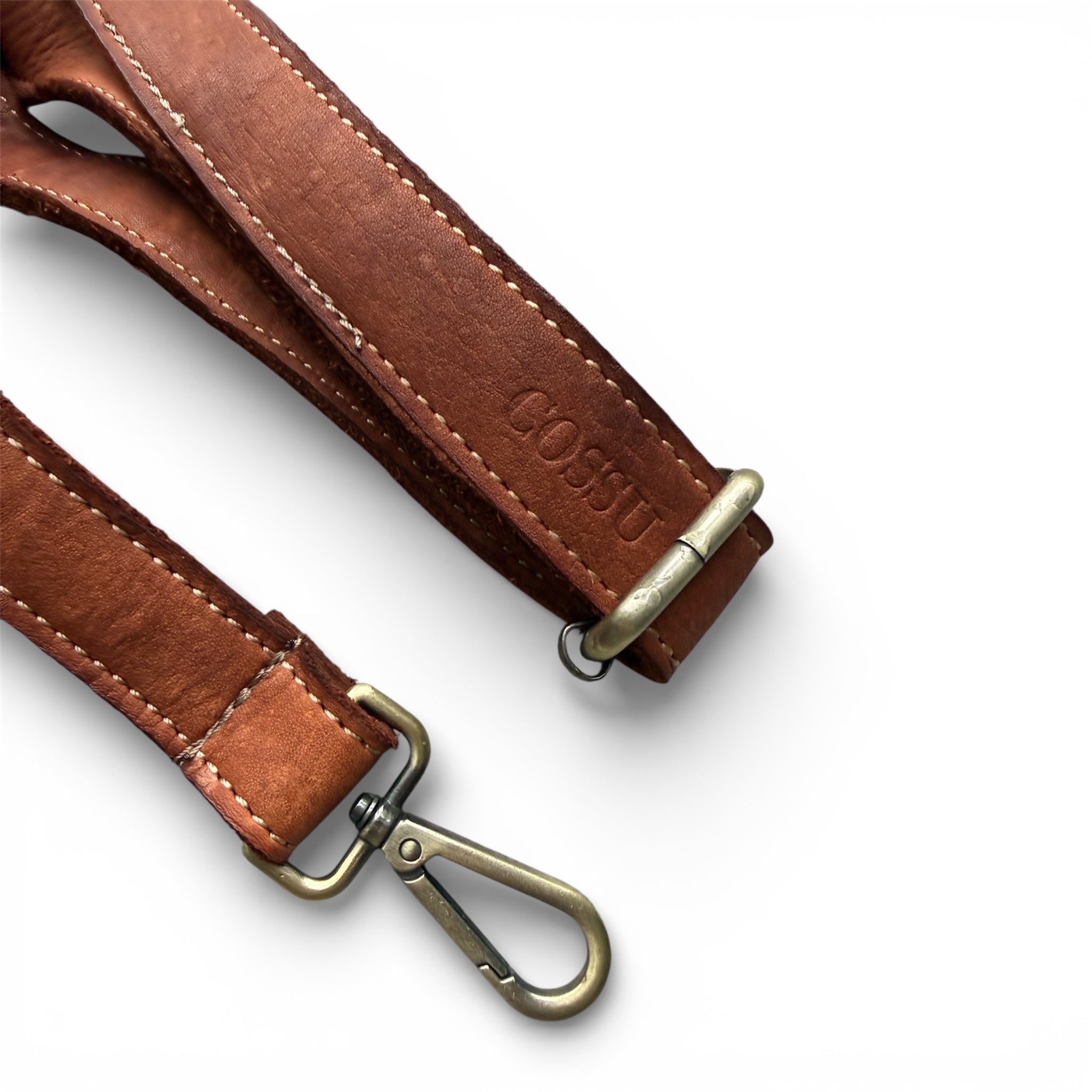 Brown leather strap with brass hardware on a white background