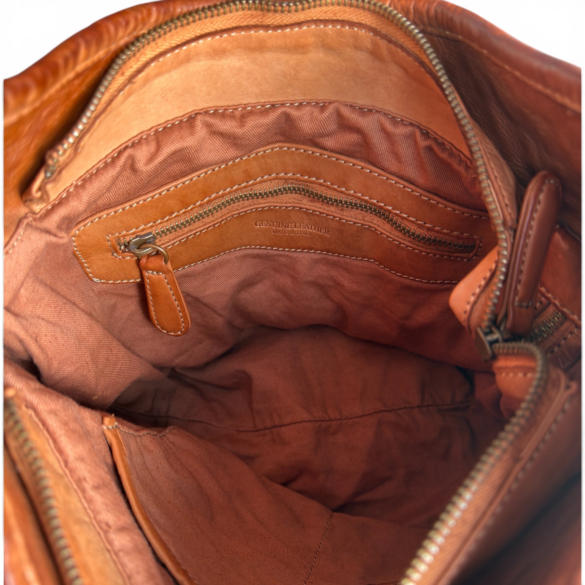 Showing inside of a Tan leather handbag with an inside zip , U.K. independent retailer 