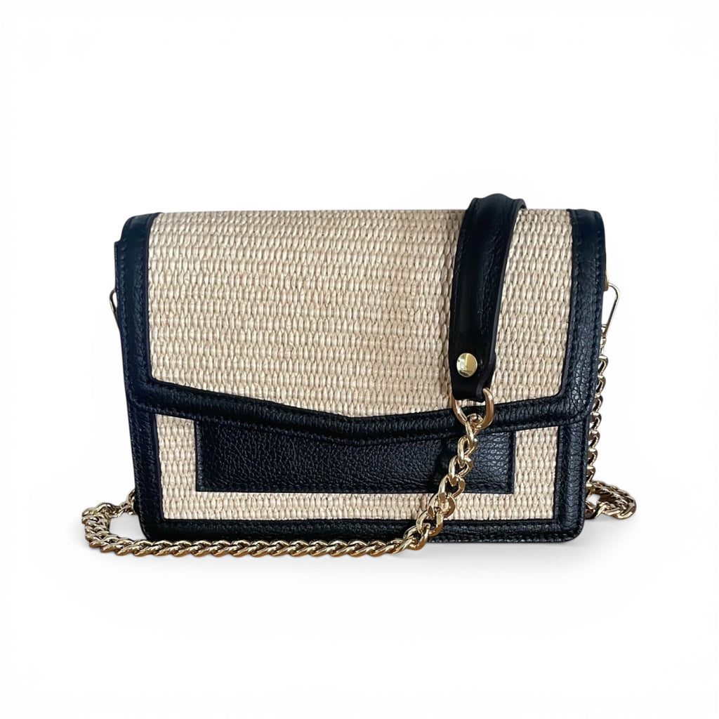 Black raffia and leather shoulder handbag with a chain detail on a white background. Made in Italy 