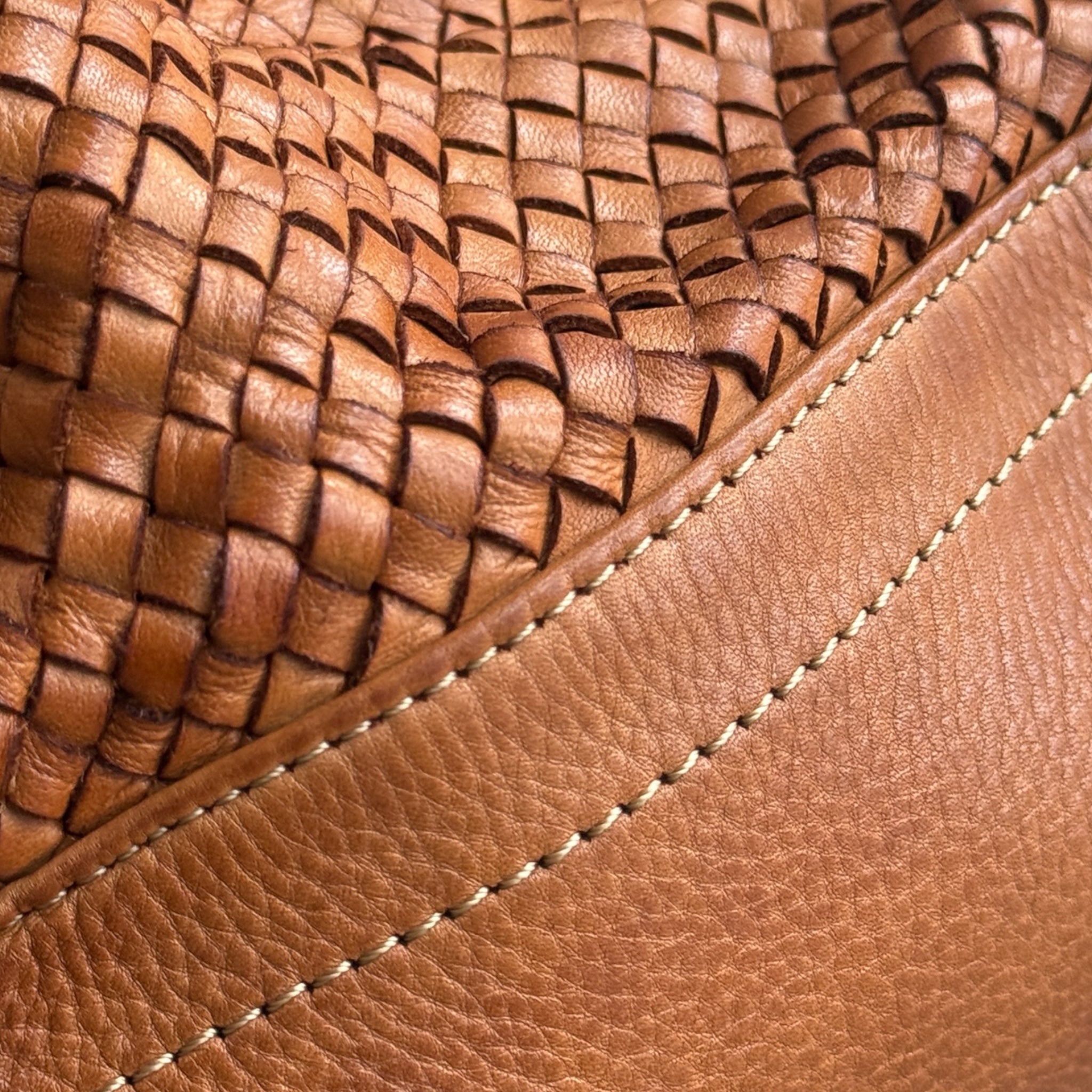 Close-up of a tan hand woven Italian leather bag with visible stitching. Made in Florence Italy U.K. independent retailer 